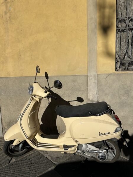Vespa bike leaning against the wall in Italy